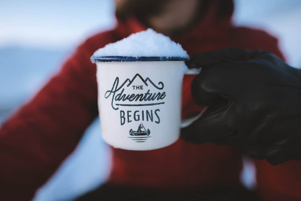 Man with The Adventure Begins mug filled  with ice
